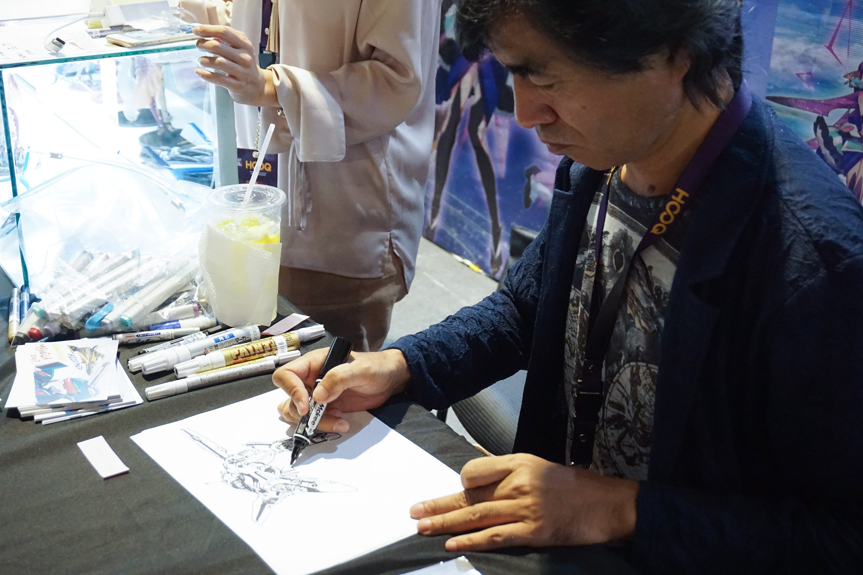 SHOJI KAWAMORI. Japanese artist Shoji Kawamori, famous for his mecha designs, draws for fans on the APCC 2017 convention floor.  