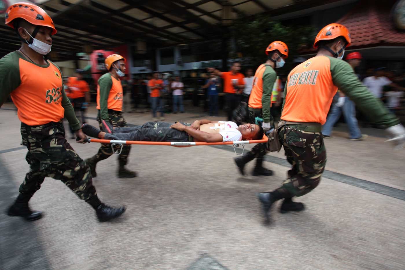 RESPONSE. An injured person is taken to an ambulance during the 2015 #MMShakeDrill. Photo by Mark Cristino/Rappler  