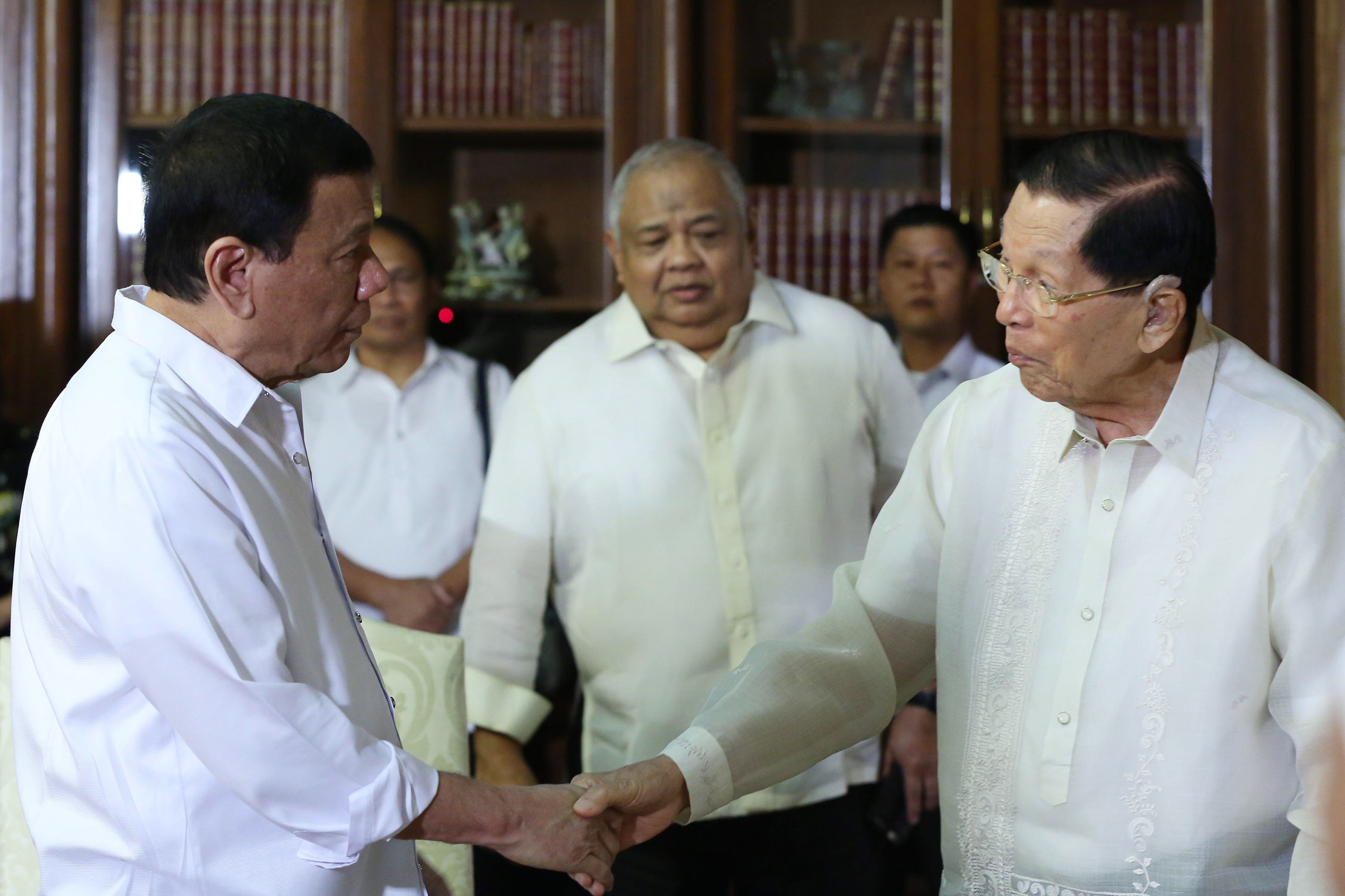 CHITCHAT. Executive Secretary Salvador Medialdea (center) looks on as President Duterte shakes hands with Juan Ponce Enrile. Presidential photo 