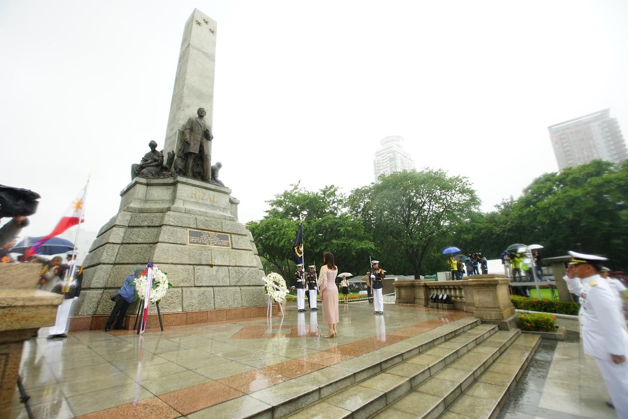 DRENCHED. Vice President Leni Robredo honors the Philippine flag as the rain falls around her. Photo by Maria Tan/Rappler 