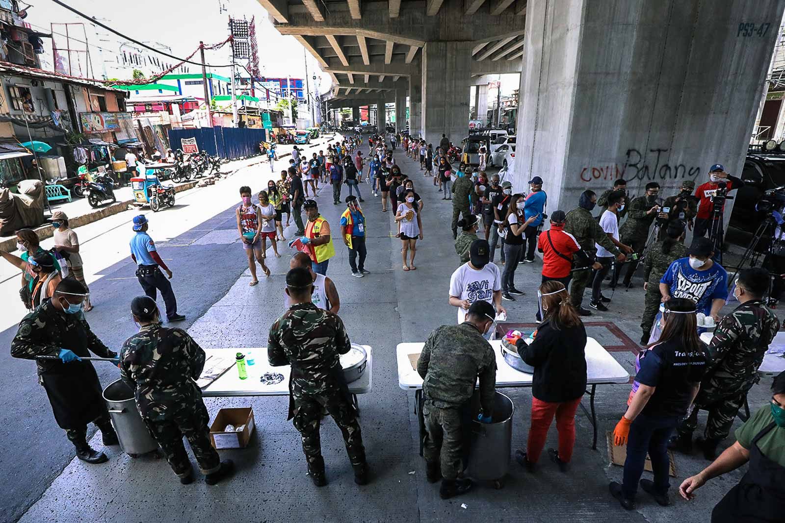 LINING UP. Member of the Armed Forces of the Philippines handed food assistance through the AFP'ss Mobile Kitchen feeding program to residents at Brgy. Tatalon in Quezon City on April 20, 2020. Photo by Darren Langit/Rappler 