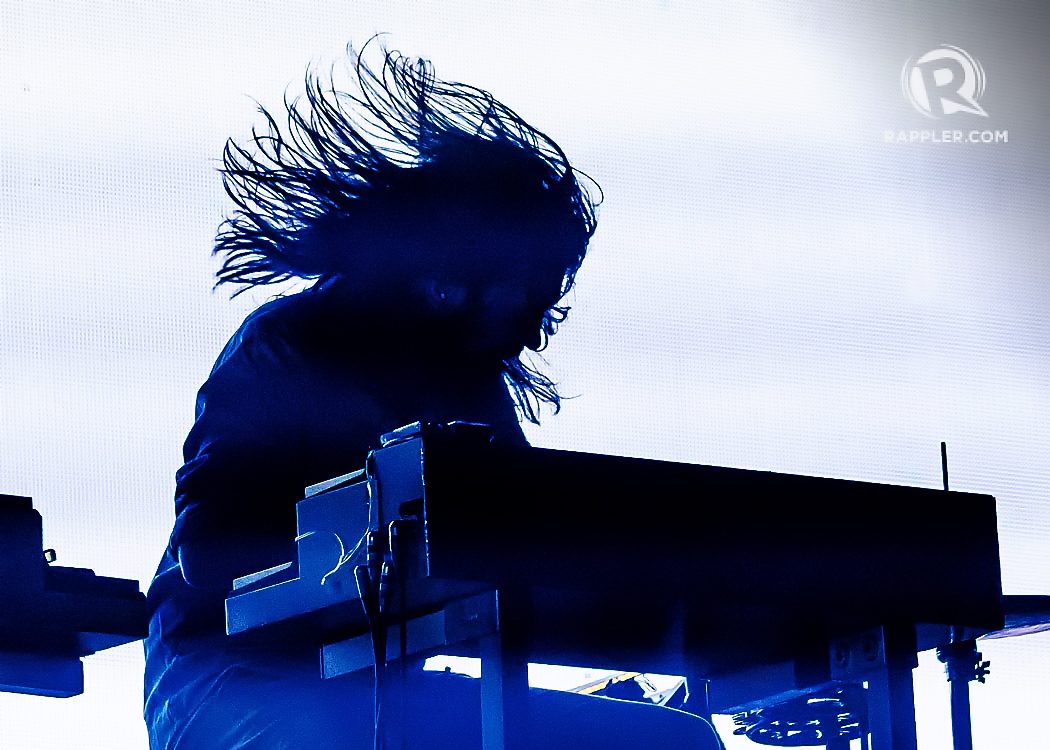 ROB COUDERT. The touring musician for Phoenix on keys and percussion in silhouette with his hair flying.  