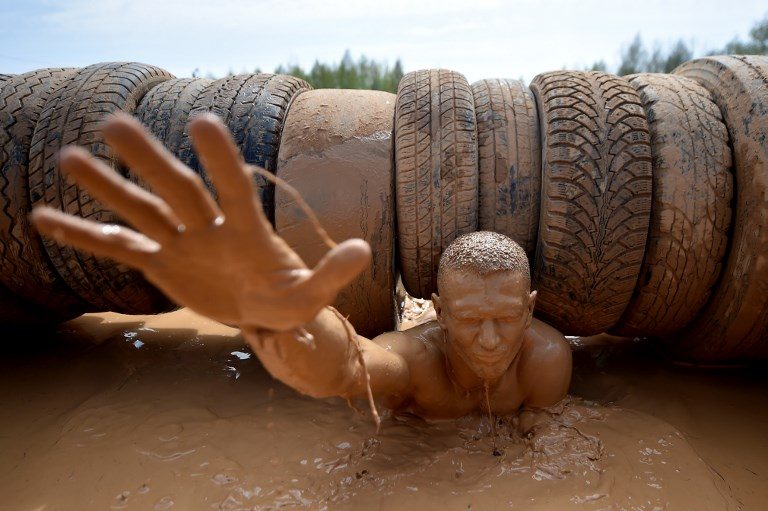 EXTREME BELARUS. A man passes an obstacle as he takes part in the 'Bison Race' extreme competition near the town of Lahoysk, Minsk, on April 30, 2018. / AFP PHOTO / Sergei GAPON  
