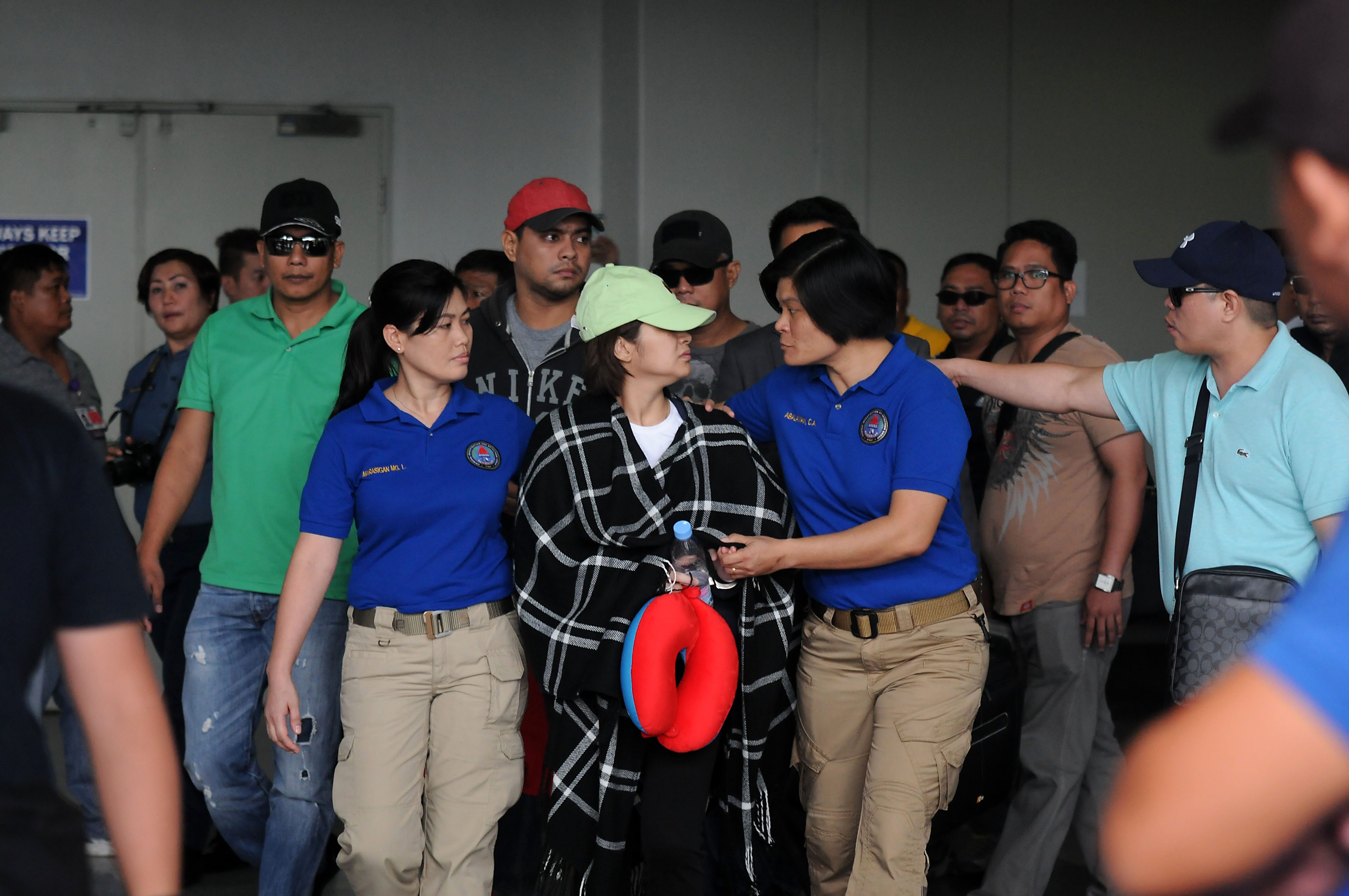 ARRESTED. Ozamiz City Vice Mayor Nova Princess Parojinog-Eschavez and her brother Reynaldo Parojinog Jr. (in red bull cap) are escorted by the CIDG as they arrive at the NAIA terminal 3 in Pasay City on July 31, 2017. Photo by Ben Nabong/Rappler 