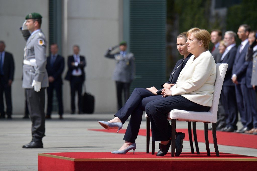 Merkel sits through anthems after shaking spells