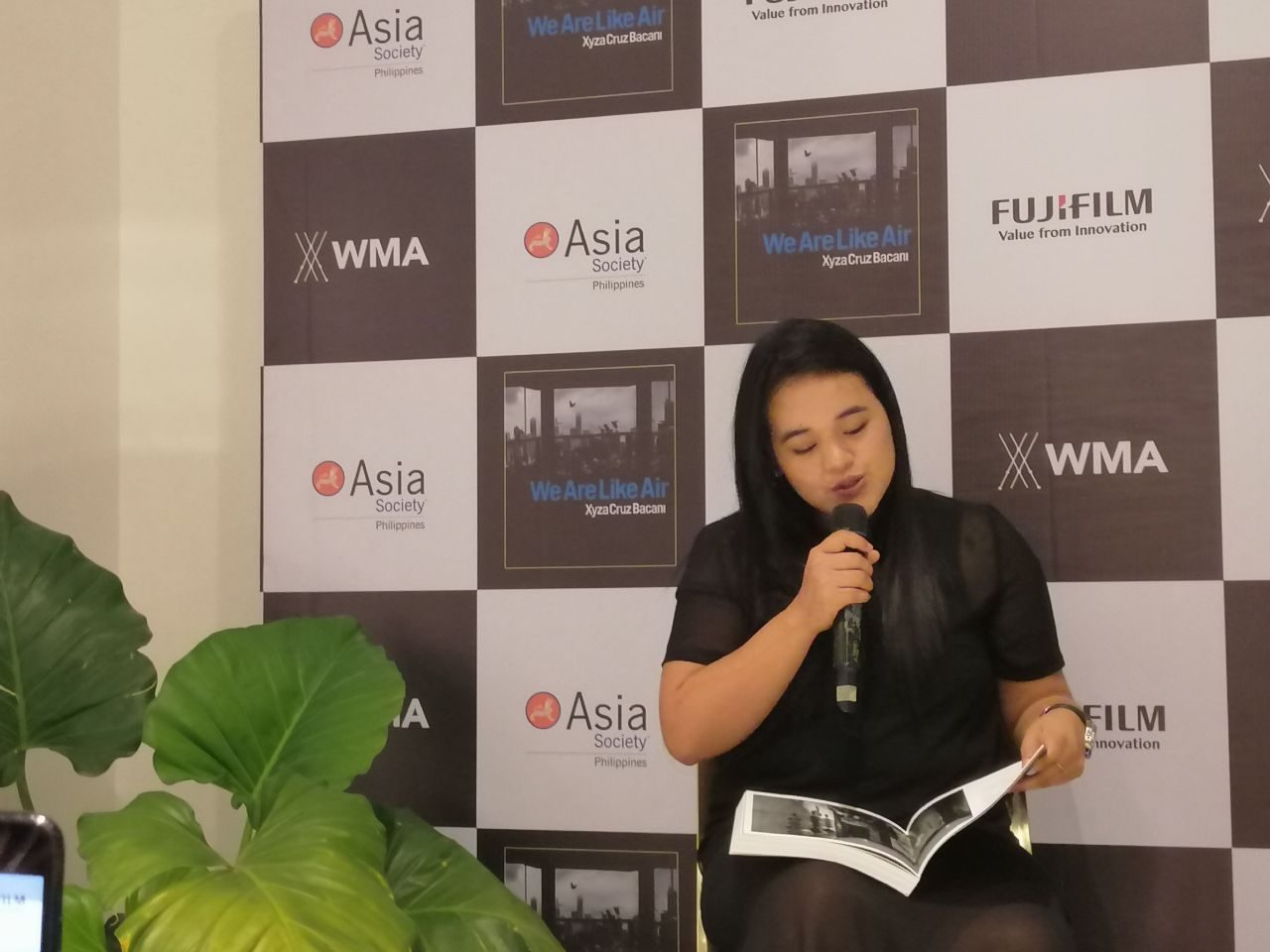 OPENING UP. Xyza Bacani reads a passage from 'We Are Like Air,' telling the story of how her mother left their family to work in Singapore. Photo by Amanda Lago/Rappler 