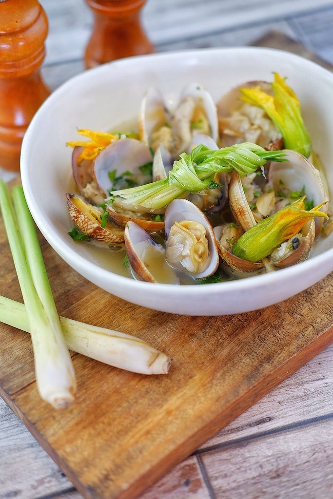 STEAMED CLAMS. Manila clams, oyster mushrooms, and squash blossom are steamed in coconut water. 