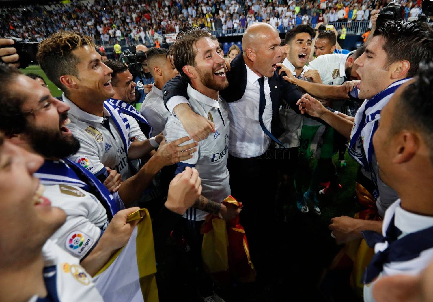 PERAYAAN. Kapten Real Madrid Sergio Ramos dan pelatih Zinedine Zidane berangkulan di tengah-tengah lingkaran pemain. Foto dari realmadrid.com 