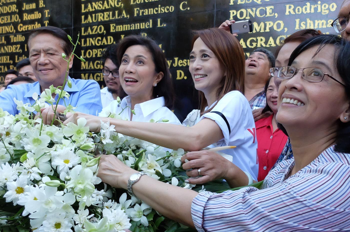 Vice President Leni Robredo joins former senator Wigberto Tanada in a flower offering for 'heroes' at the Bantayog ng mga Bayani's wall of remembrance 