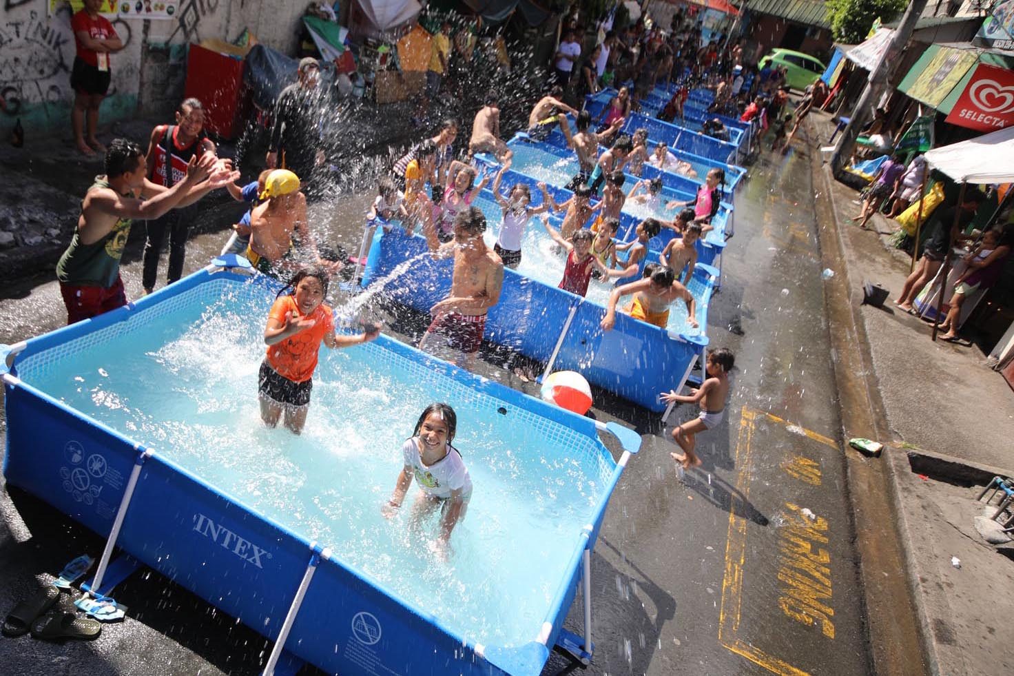BEATING THE HEAT. Children enjoy the water on inflatable pools installed along the street of Barangay Batis in San Juan City on April 12, 2018. Photo by Darren Langit/Rappler  
