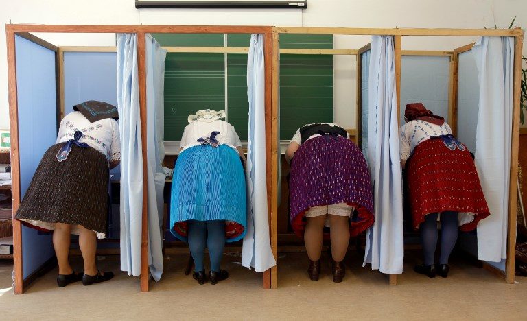 HUNGARY VOTE. Women dressed in traditional Hungarian wear prepare their votes in a polling station in a school in Veresegyhaz on April 8, 2018, during the general elections. Photo by Peter Kohalmi/AFP  