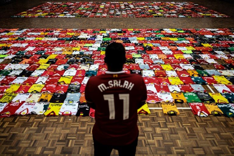 WORLD RECORD ATTEMPT. A fan of the Liverpool football team stands in-front of the 1,278 jerseys displayed side by side on the floor during the Malaysia Book of Records event for the most number jerseys on display of a single team in Kuala Lumpur on April 11, 2018. Photo by Mohd Rasfan/AFP   