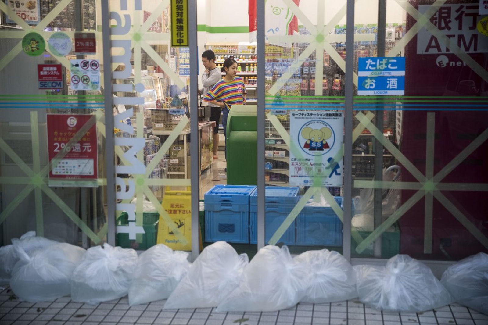 PREPARED. Taped up windows and bags filled with water to counter a flood surge greet last dash shoppers at a convenience store in the Shinagawa district of Tokyo on October 12, 2019, as the effects of Typhoon Hagibis begin to be felt in Japan's capital. Photo by Odd Andersen/AFP  