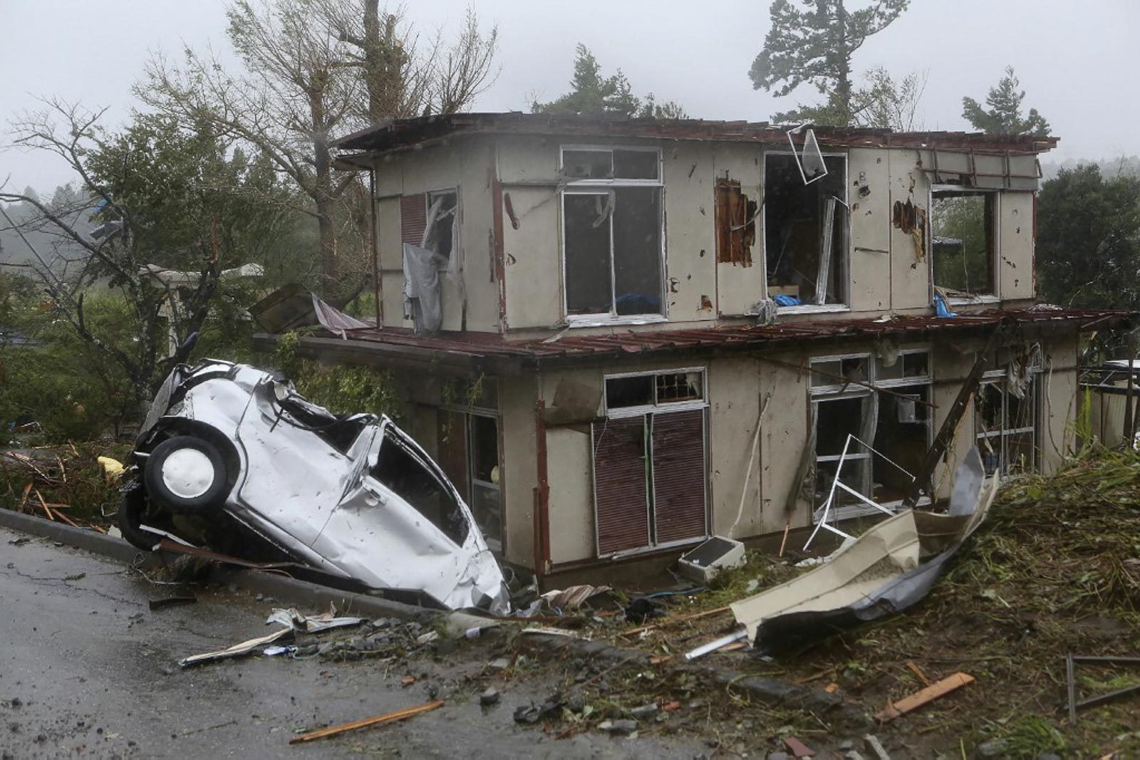 DESTRUCTION. A damaged vehicle sits in a ditch next to a badly damaged house after strong winds brought by Typhoon Hagibis hit the area in Ichihara, Chiba prefecture on October 12, 2019. Photo by Jiji Press/AFP  