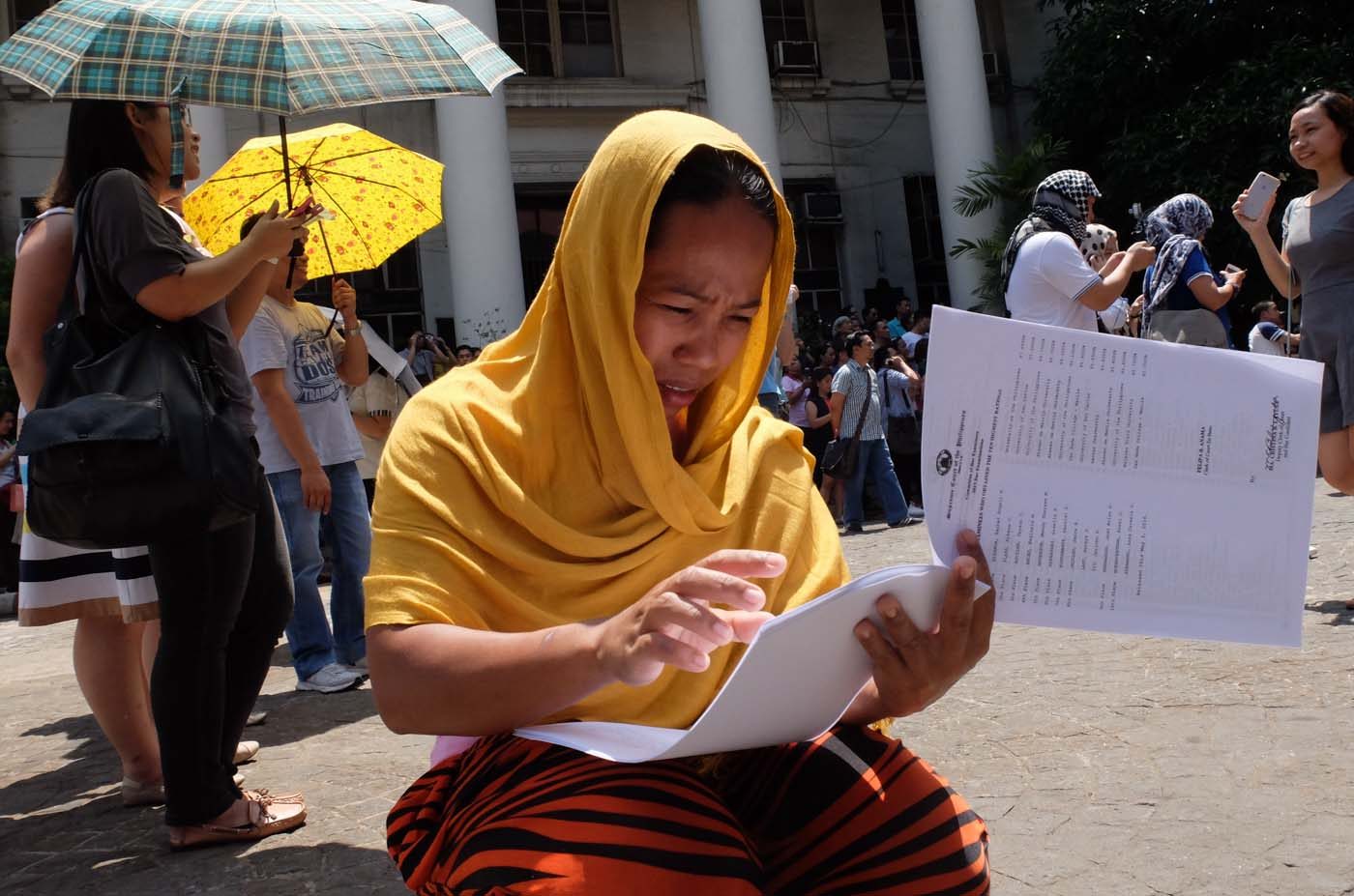 RESULTS. A woman flips through the list of successful Bar examinees, May 3, 2016. Photo by Alecs Ongcal/Rappler 