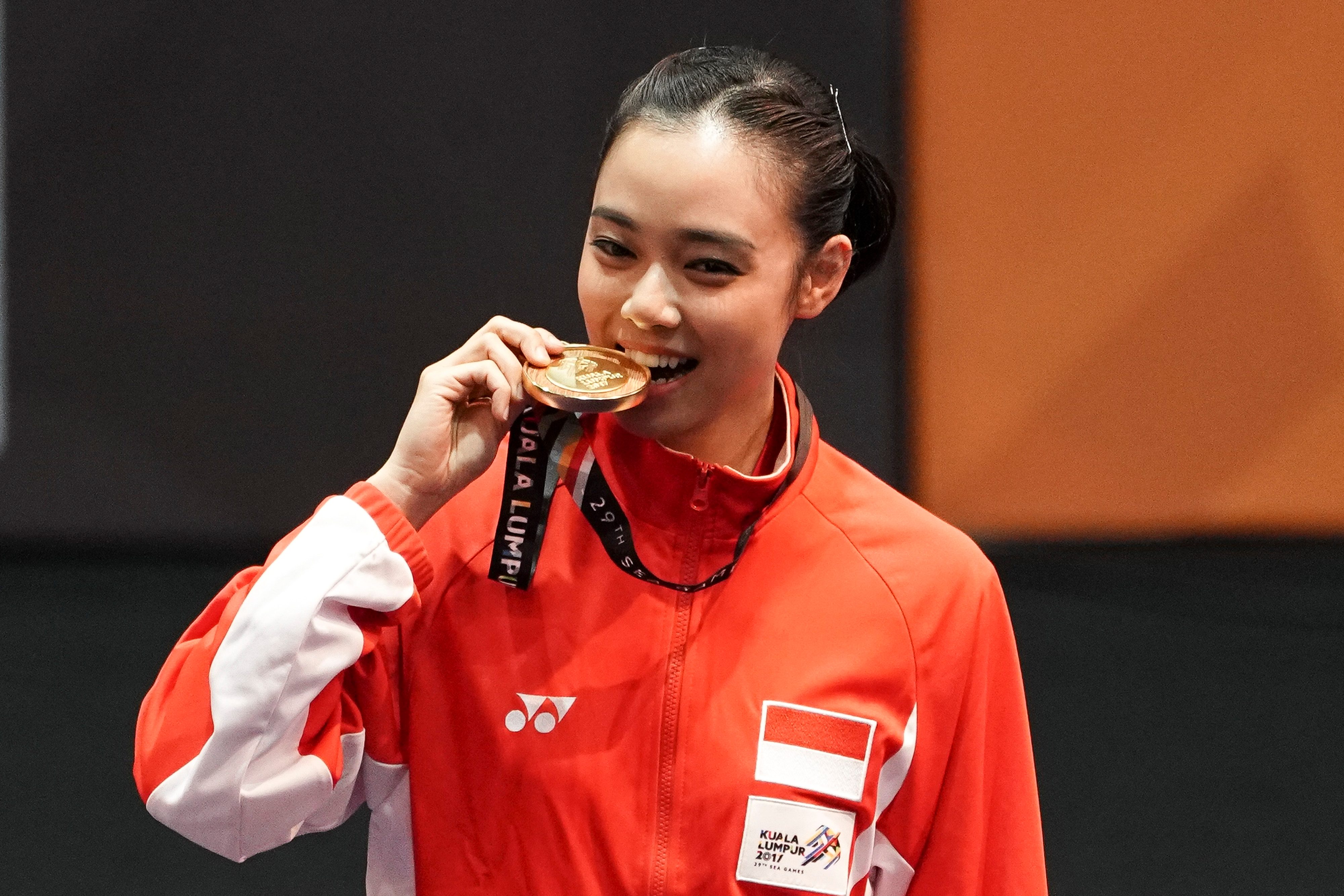 Atlet wushu Indonesia Lindswell Kwok menggigit medali ketika upacara penyerahan medali wushu nomor Taijijian putri di KLCC, Kuala Lumpur, Malaysia, pada 21 Agustus 2017. Foto oleh Wahyu Putro A/Antara
 