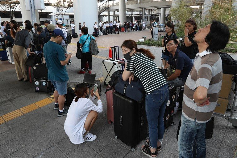 Passengers stranded at the Kansai International Airport due to typhoon Jebi wait for buses that will transport them from the airport in Izumisano city, Osaka prefecture on September 6, 2018. Photo by Jiji Press/AFP 