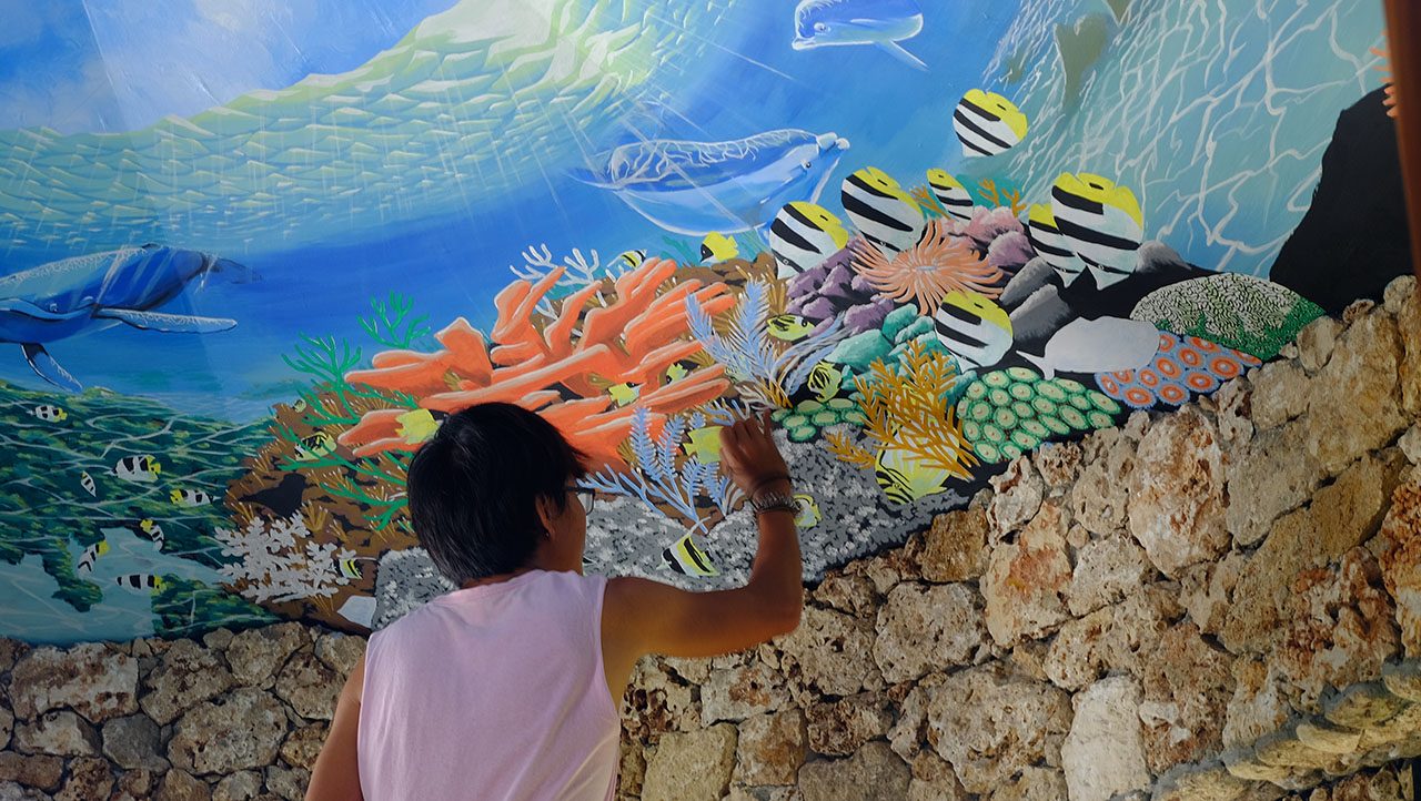 CELEBRATING LUNA'S MARINE LIFE. An artist works on a mural. Photo courtesy of Laurie Mae Gucilatar, Joms Santos, and Eleazar Cuela     