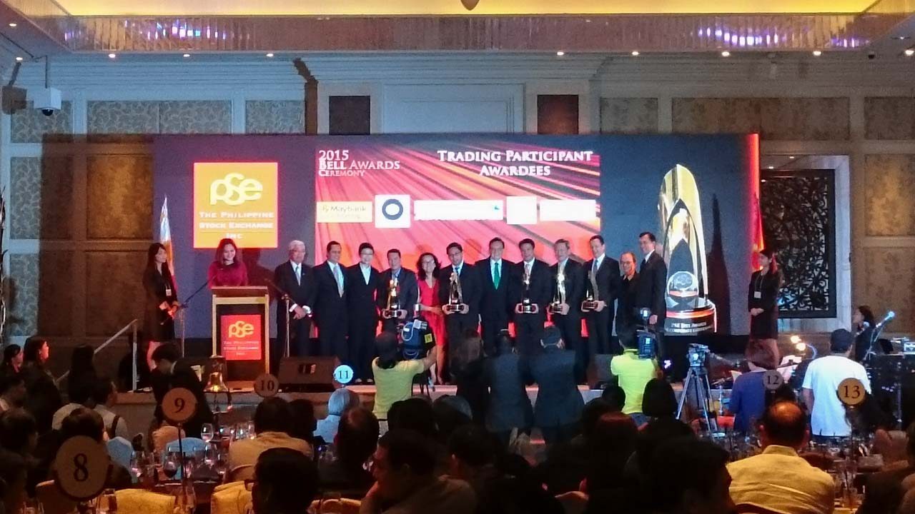 TRADING PARTICIPANT WINNERS. Representatives from the 5 trading participant winners: Maybank ATR Kim Eng Securities, Deutsche Regis Partners, Credit Suisse Securities Philippines, Macquarie Capital Securities Philippines, and R.S. Lim and Company show off their awards to the audience at the 2015 PSE Bell Awards.  
