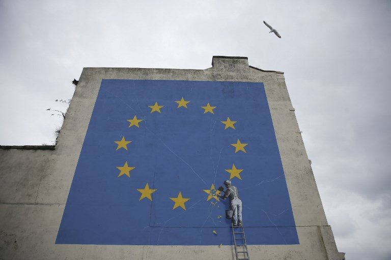 BREXIT. A mural by British artist Banksy, depicting a workman chipping away at one of the stars on a European Union-themed flag, is pictured in Dover, south east England, on March 19, 2018. Photo by Daniel Leal-Olivas/AFP  