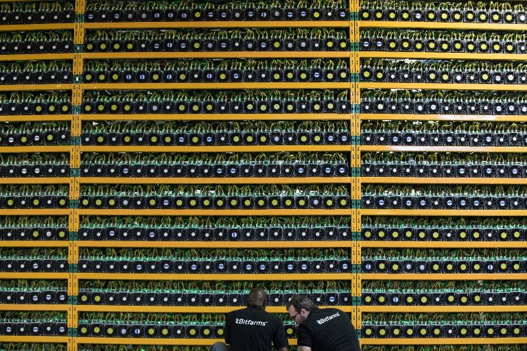 CRYPTOCURRENCY. Two technicians inspect bitcoin mining at Bitfarms in Saint-Hyacinthe, Quebec, Canada, on March 19, 2018. Photo by Lars Hagberg/AFP   