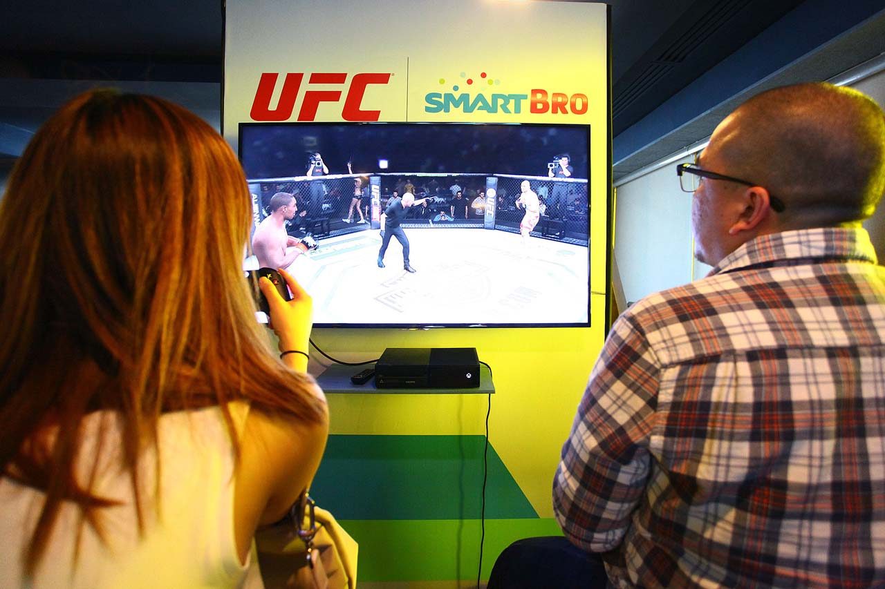 RELIVE THE ACTION. Fans try their hand at the UFC video game 