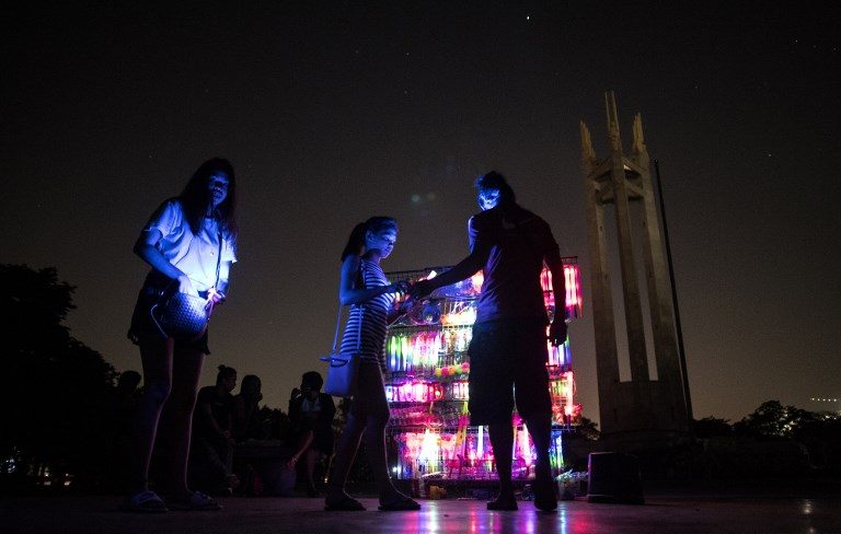 LIGHT UP. A vendor sells light-up yoyos in front of the Quezon Memorial Shrine after the lights were switched off for Earth Hour 2018. Photo by Noel Celis/AFP 