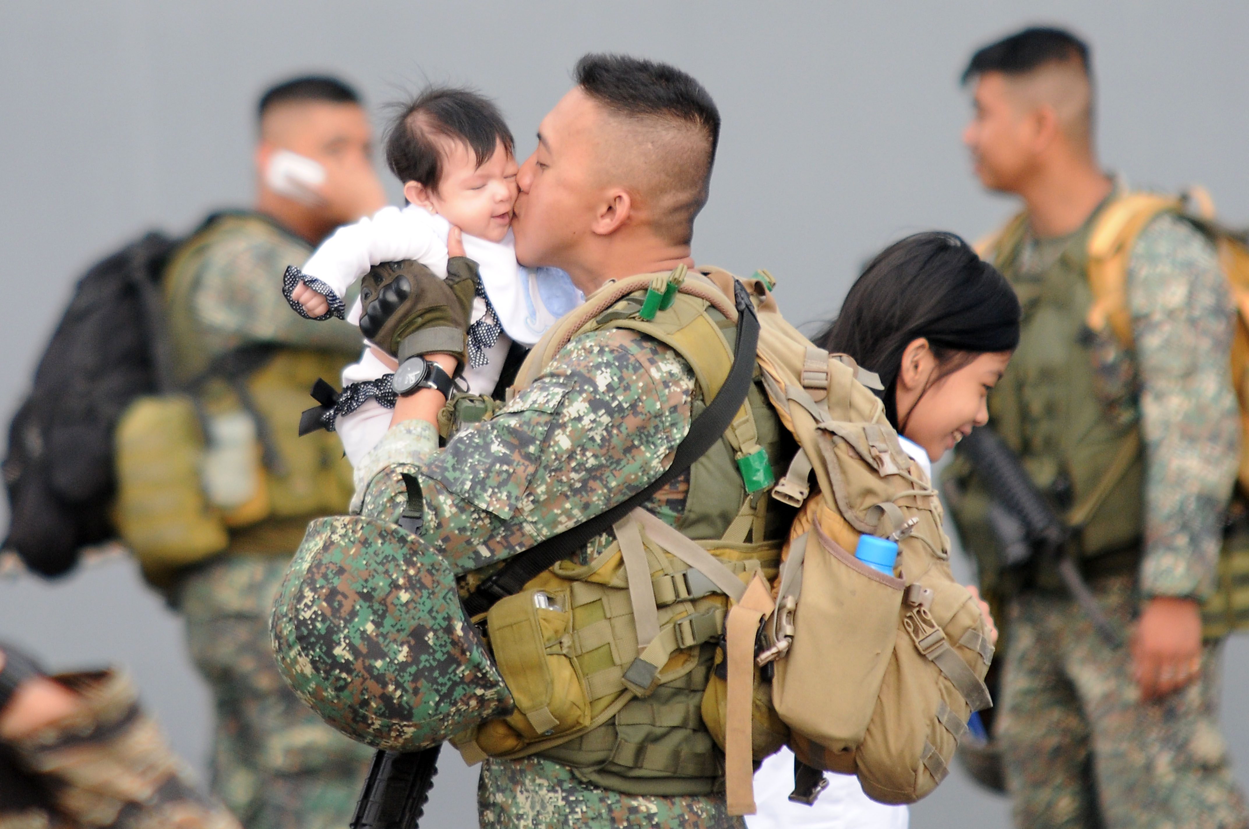 BACK HOME. A Philippine marine kisses his child after arriving on board the BRP Tarlac at the Philippine navy headquarters in Manila on October 30, 2017, after battling ISIS inspired Maute terrorist for 5 months. Photo by Ben Nabong/Rappler   