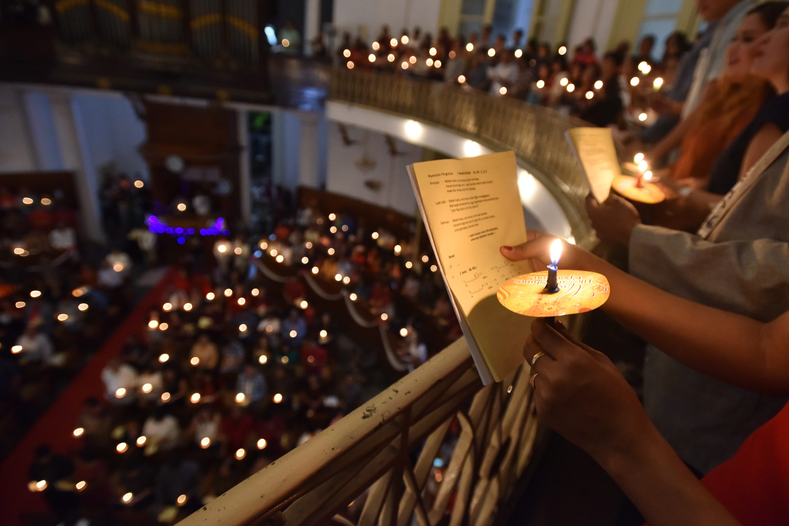 Umat Kristiani menyalakan lilin ketika mengikuti misa malam Natal di Gereja Immanuel, Jakarta, pada 24 Desember 2016. Foto oleh Wahyu Putro A/Antara 