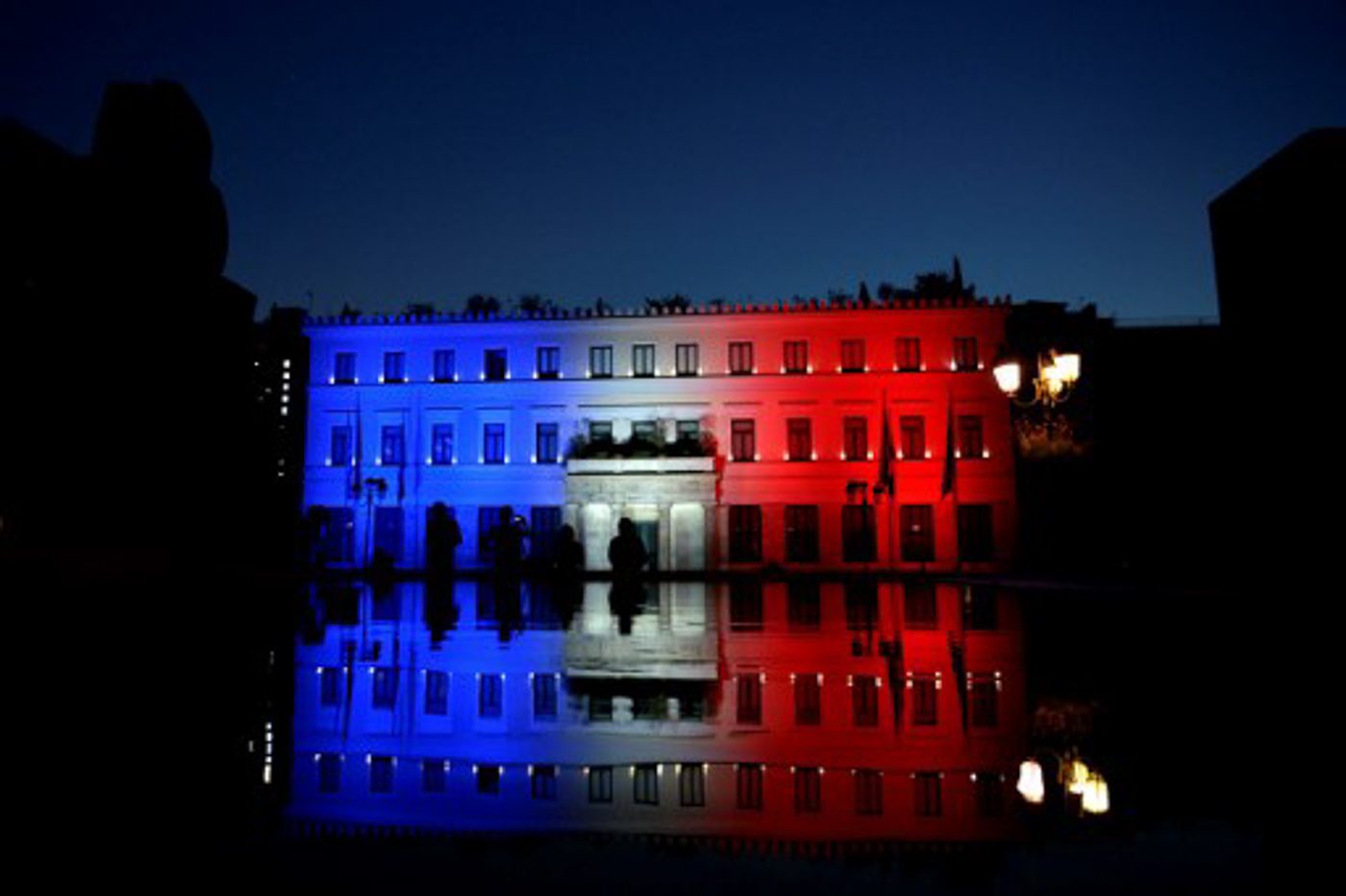 GREECE. People take photos of the Athens City Hall as it illuminates with the colors of the French national flag.  