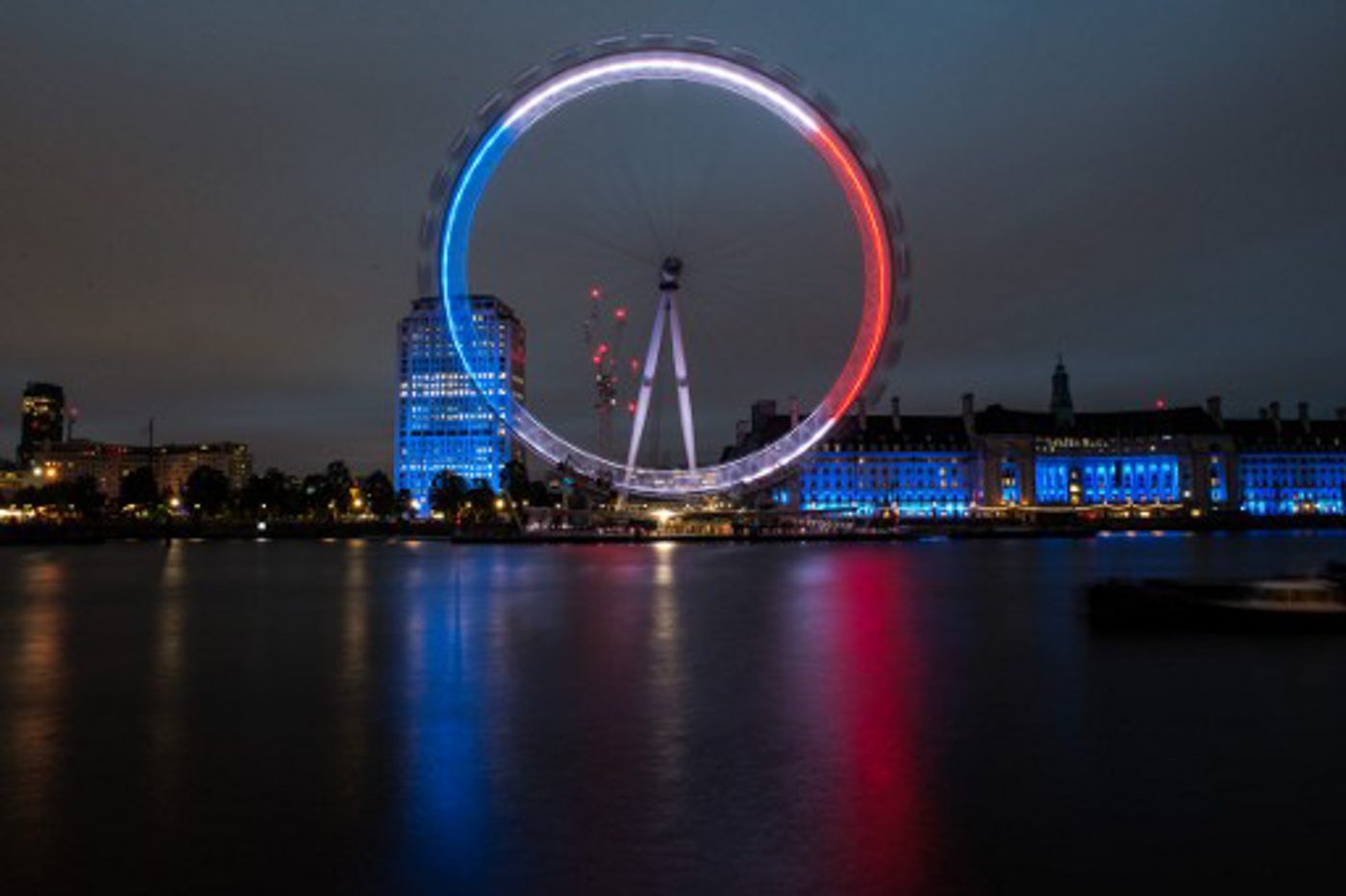 BRITAIN. The London Eye in blue, white and red lights.  