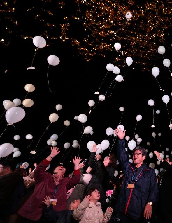 Orang-orang Jepang menyambut tahun baru dengan melepaskan balon yang membawa harapan mereka, di depan Prince Park Tower, Tokyo, pada 1 Januari, 2017.  Foto oleh Behrouz Mehri/ AFP   
