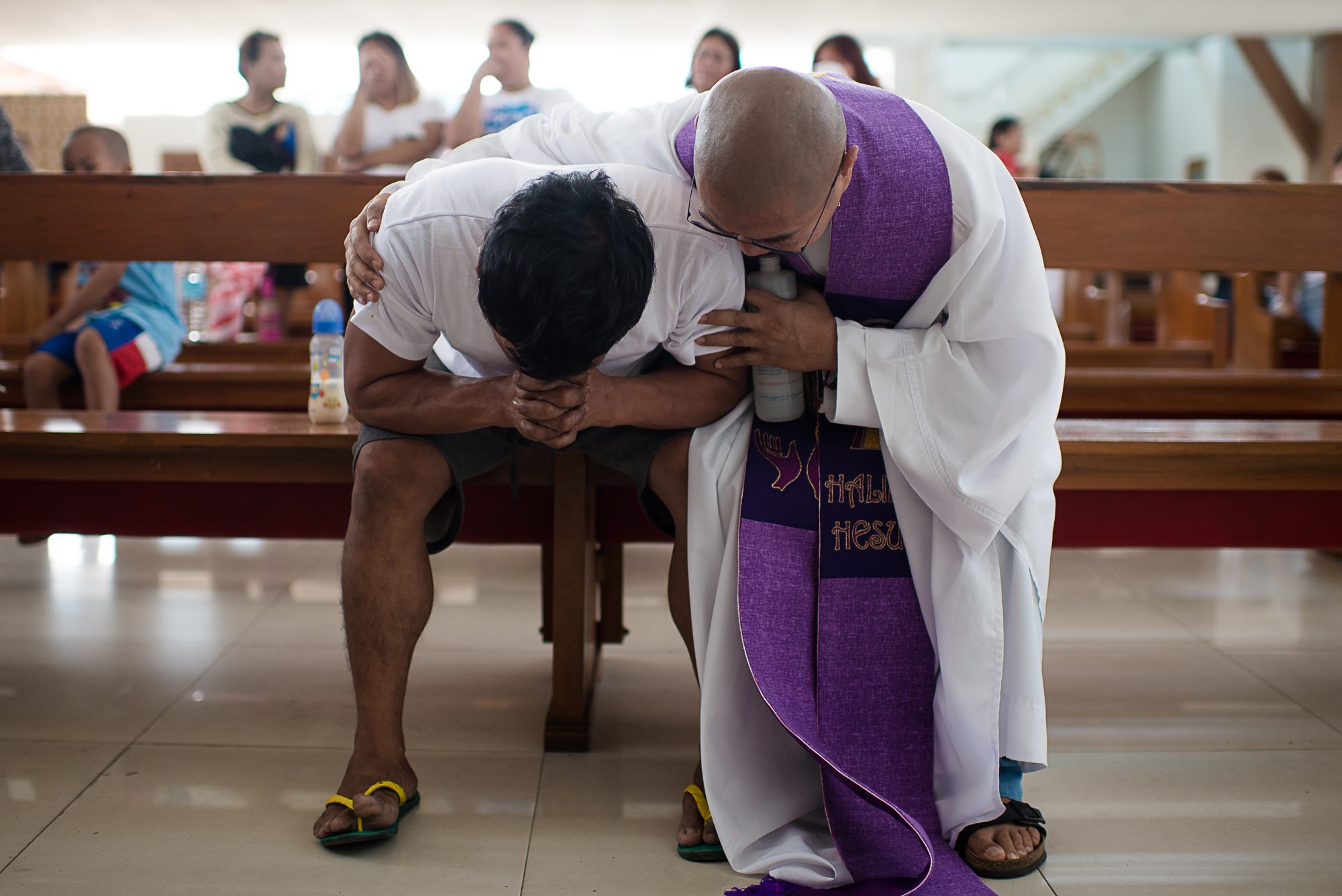 COMFORT. Allan Pineda, father of the victim, is comforted by Father Flavie Chalaf as cries inconsolably during the burial mass in Risen Christ Parish. Photo by Eloisa Lopez/Rappler 