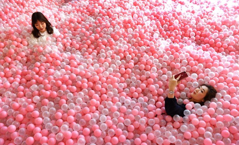 DESSERT MUSEUM. A visitor of Sugar Republic takes a selfie as she reclines in a display of balls resembling lollies in Melbourne, Australia on July 24, 2018. Photo by William West/AFP  