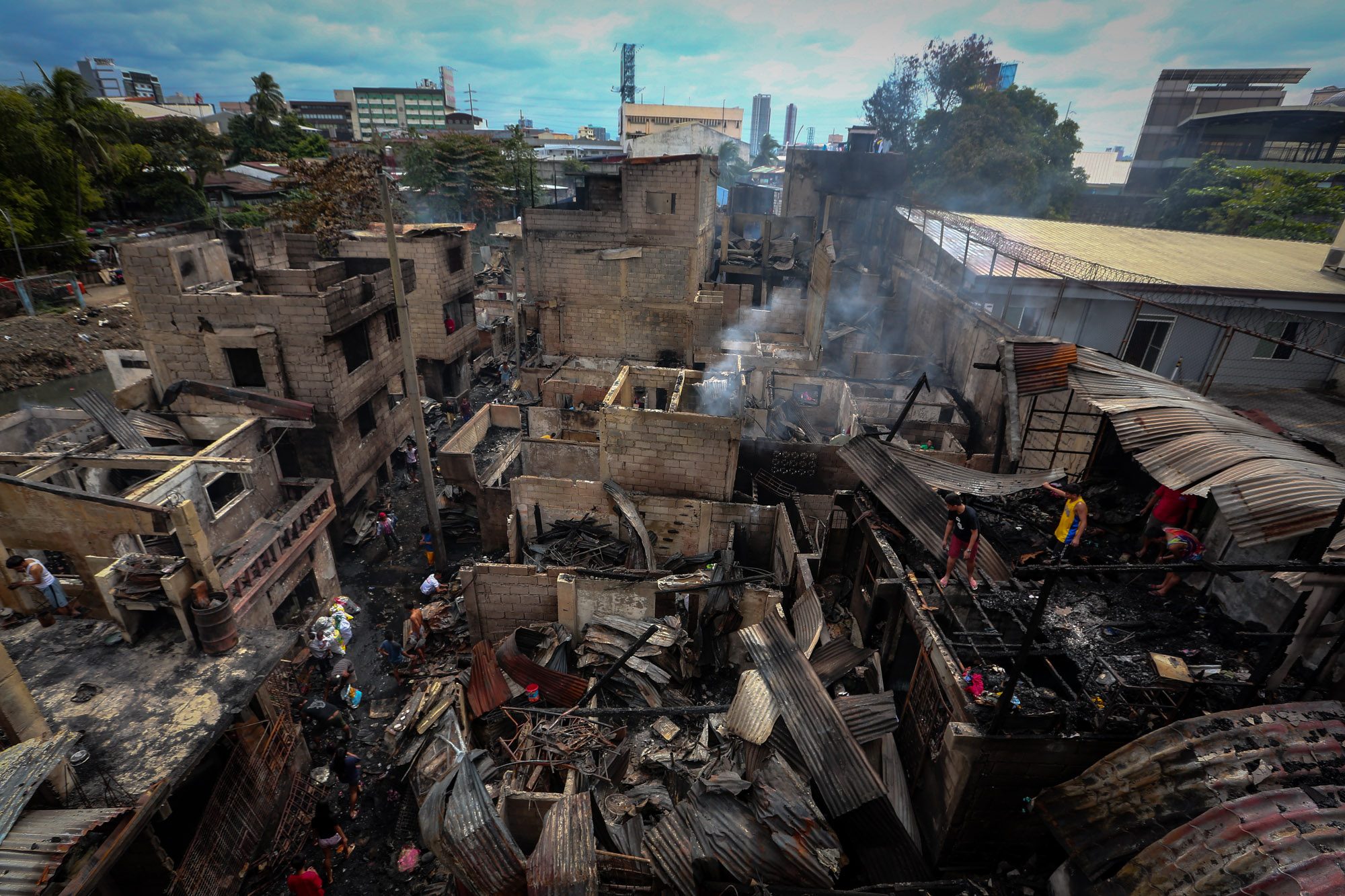 AFTERMATH. Residents of Talayan, Quezon City, on January 29, 2019, pick up the pieces and pore over what was left of their homes after a blaze razed their community on January 28, 2019. Photo by Jire Carreon/Rappler  