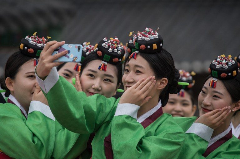 COMING OF AGE. South Korean students pose for a selfie following a traditional coming-of-age ceremony at Namsan hanok village in Seoul on May 15, 2017. The ceremony marks the age of 19, at which a person is legally able to make life choices from voting, to drinking alcohol. Photo by Ed Jones/AFP  