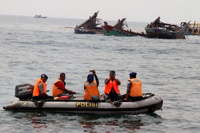 ILLEGAL FISHING. Police on a boat are seen past the remnants of illegal fishing boats blown up with explosives by Indonesian authorities in April 5, 2016. 
File photo by AFP   