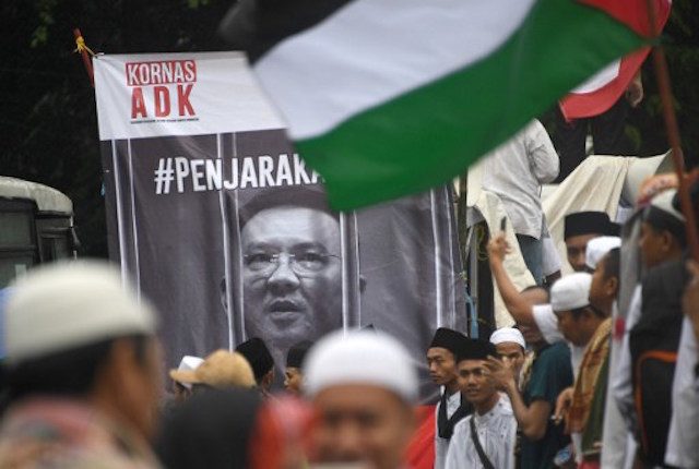 DEMONSTRATIONS. Indonesian protesters chant in front of a poster of Basuki Tjahaja Purnama, as they march down the capital city's main street after a demonstration at Jakarta's National Monument Park. AFP PHOTO / GOH CHAI HIN 