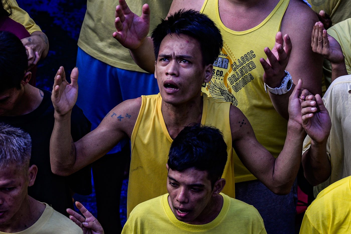 IN THE MOMENT. An inmate raises his hands while singing the Lord's Prayer with fellow inmates. Photo by Maria Tan/Rappler 