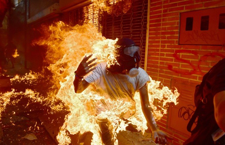 MAN ON FIRE. A demonstrator catches fire during clashes with riot police within a protest against Venezuelan President Nicolas Maduro, in Caracas, on May 3, 2017. Photo by Ronaldo Schemidt/AFP   