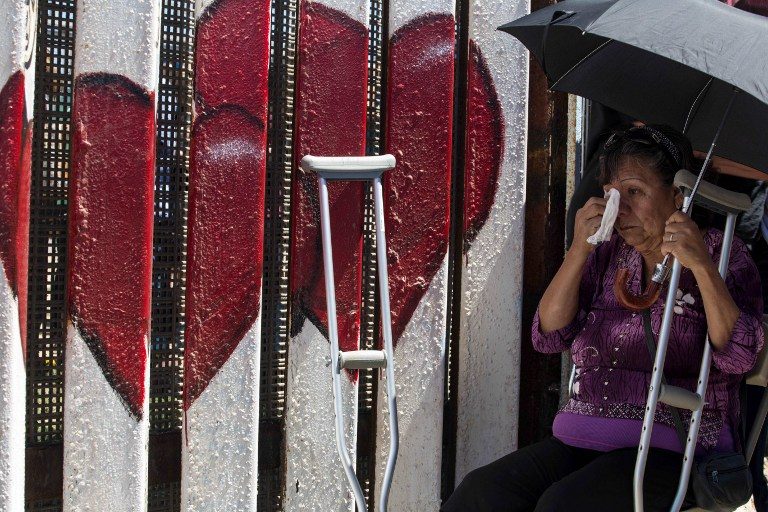 REUNION. Carmen Guitar waits to meet her family during the 'Opening the Door of Hope' event at the US-Mexico border fence gate in Playas de Tijuana, Mexico on April 30, 2017. Photo by Guillermo Arias/AFP   