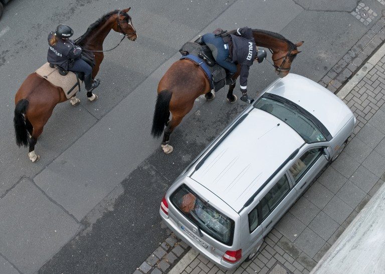 HORSEPOWER. An officer of the mounted police placess a parking ticket on a car parked on the pavement on May 3, 2017 in Hanover, northern Germany. Photo by Jochen Lübke/AFP/DPA   