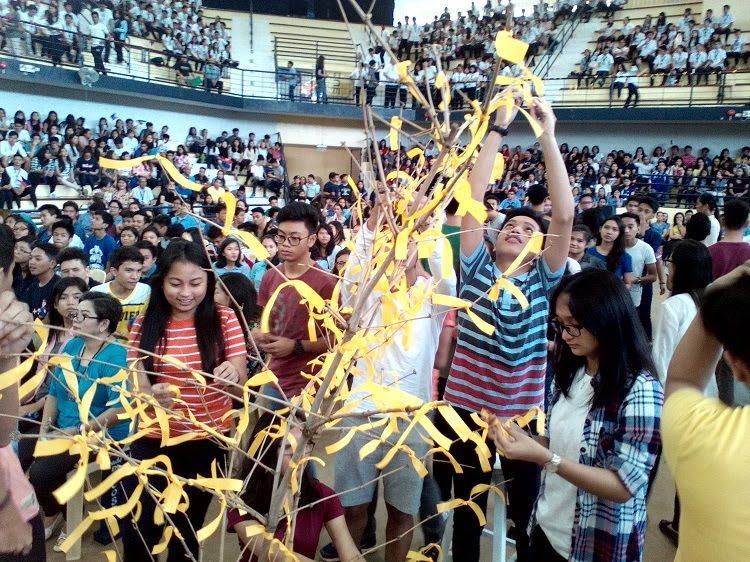 RIBBON-TYING. Students tie yellow ribbons on the branches of a decorative tree as a symbol of patriotism and nationalism. Photo by Angelo Lorenzo 