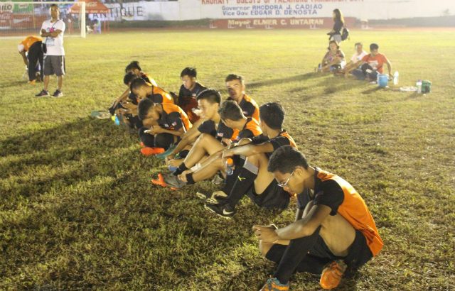 PROTEST. Region X football team sit in the Binirayan Sports Complex on Monday night, April 24 to protest NCR's no-show. Photo by JP Punzalan/Rappler   