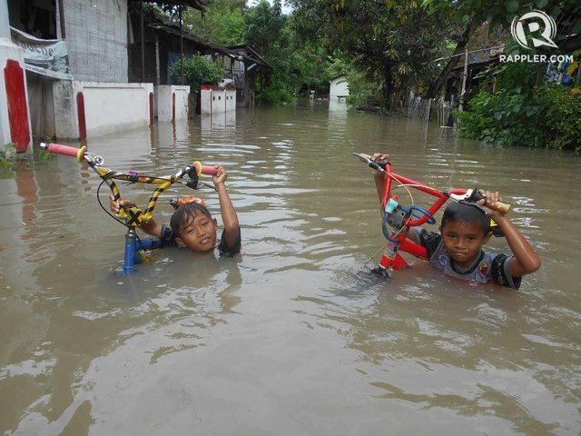 ILUSTRASI. Dua anak menenteng sepeda saat banjir merendam hampir semua rumah di Dukuh Kaliwingko, RT 03/RW I, Madegondo Grogol, Sukoharjo. Foto oleh Fariz Fardianto/Rappler 