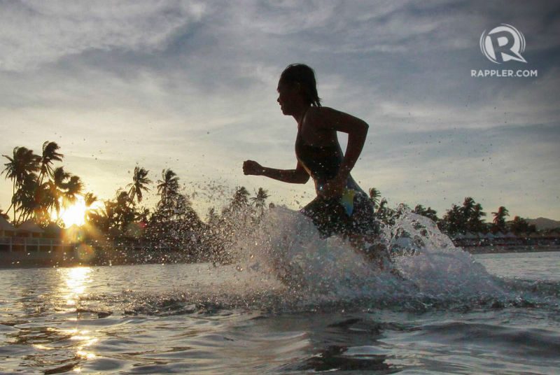 A triathlete emerges from her swim at Santiago Cove. Photo by Rappler 