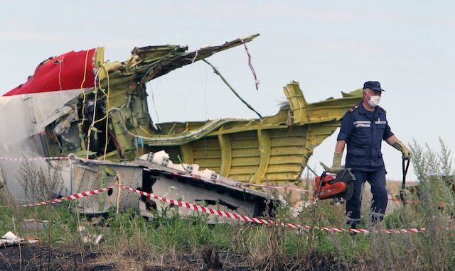 A Ukrainian worker inspects the main crash site of the Boeing 777 Malaysia Airlines flight MH17, which crashed over the eastern Ukraine region, near Grabove, some 100 km east of Donetsk, Ukraine, 20 July 2014. Igor Kovalenko/EPA