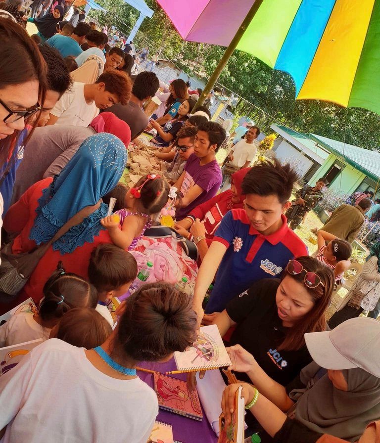 GIFT-GIVING. Movers in Isabela City, Basilan, share the table with children for distribution of Christmas gifts. Photo courtesy of Jamju Rivera  