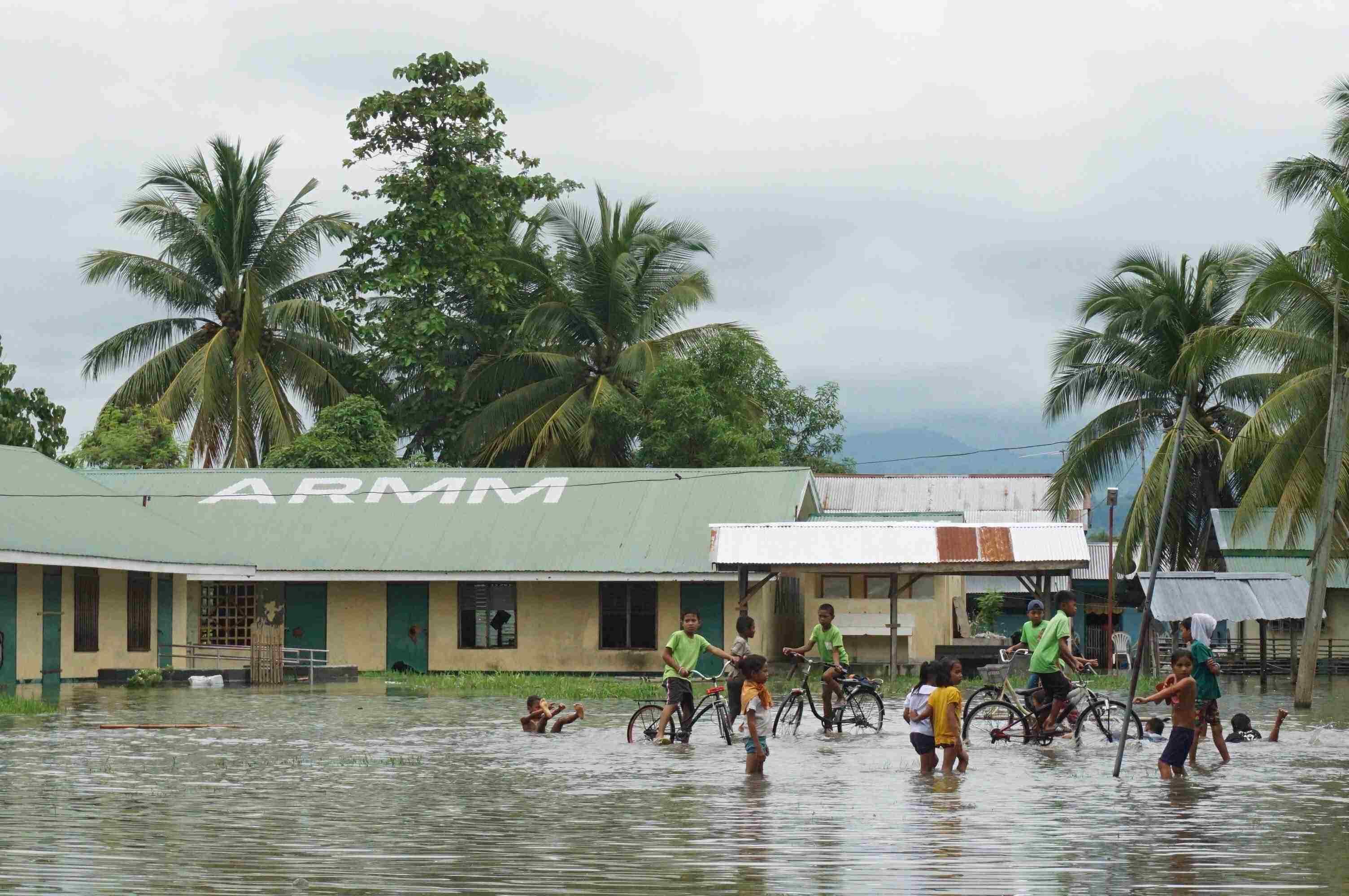 MAKING DO. Children play in the flood at the Kitango Elementary School in Datu Saudi Ampatuan in Maguindanao. Photo from Oxfam in the Philippines  