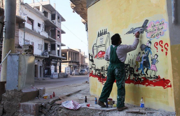 MURAL. Syrian artist Aziz al-Asmar works on a mural depicting the war in his country ahead of the start of the Astana peace talks, on January 19, 2017, in the Syrian rebel-held town of Binnish, on the outskirts of Idlib. Photo by Omar haj kadour/AFP 